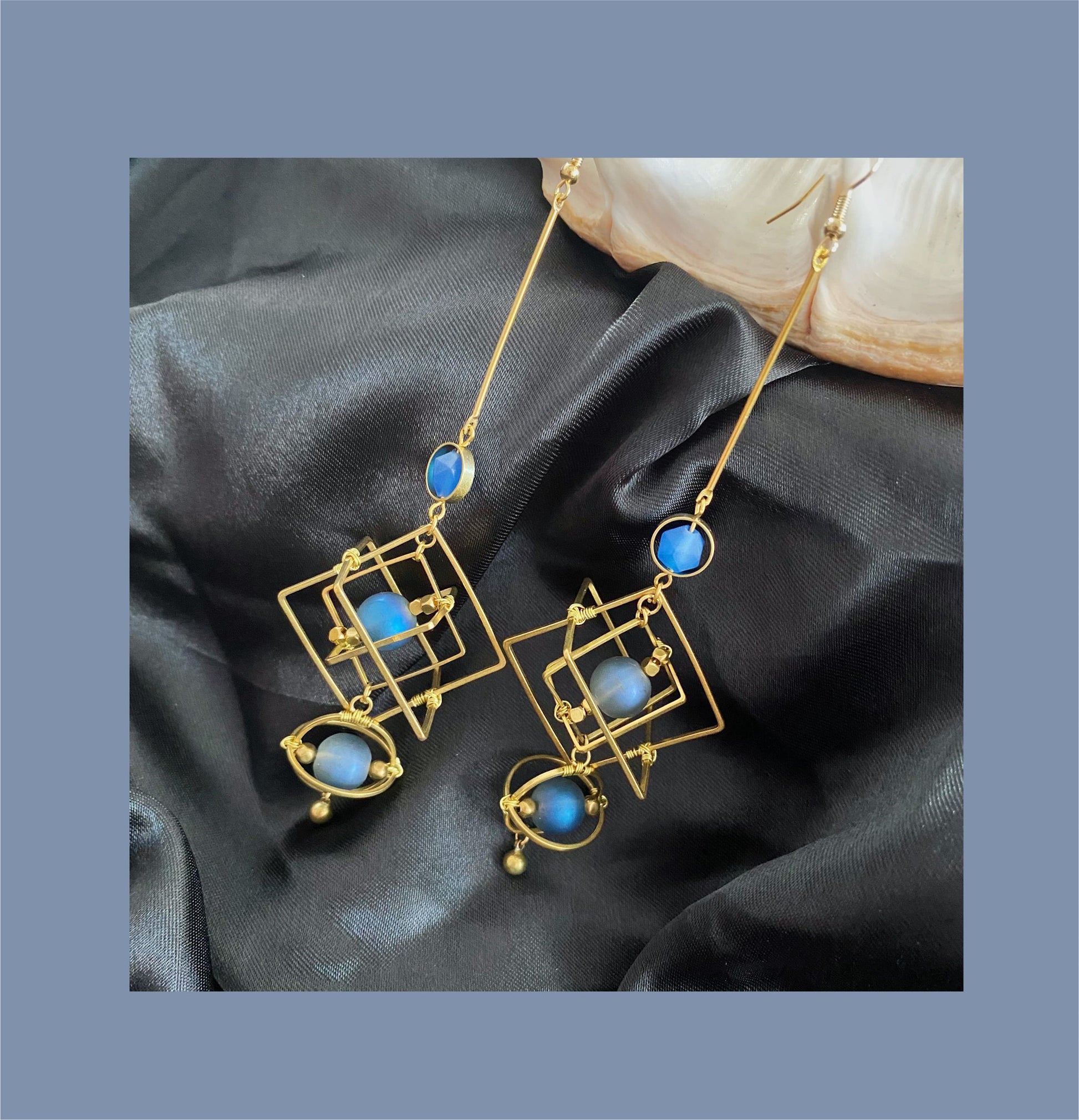 Statement gold hoops featuring blue crystal earrings with geometric designs for a stylish look