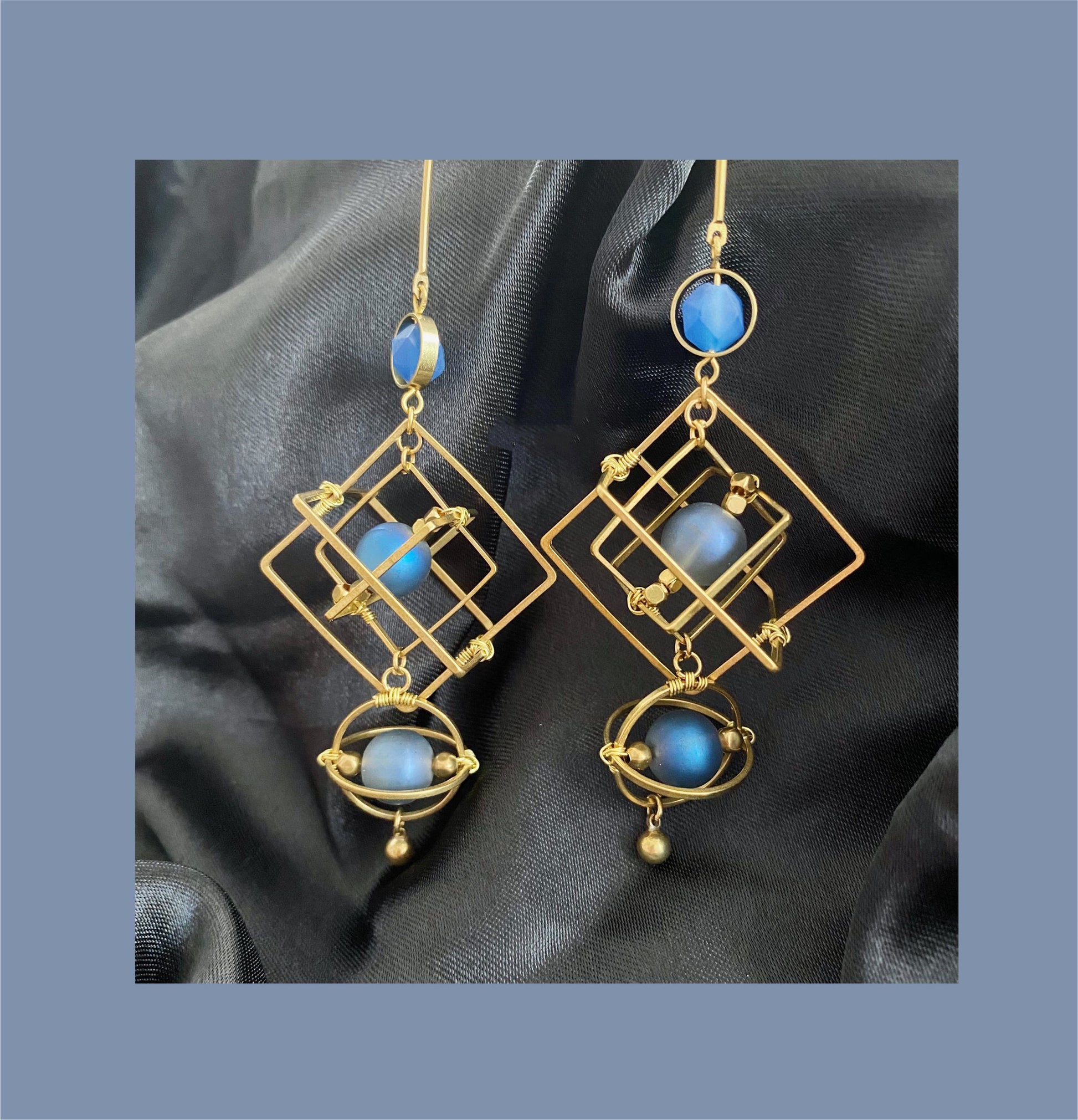 Statement Earrings featuring blue crystal earrings in a geometric gold design with blue beads