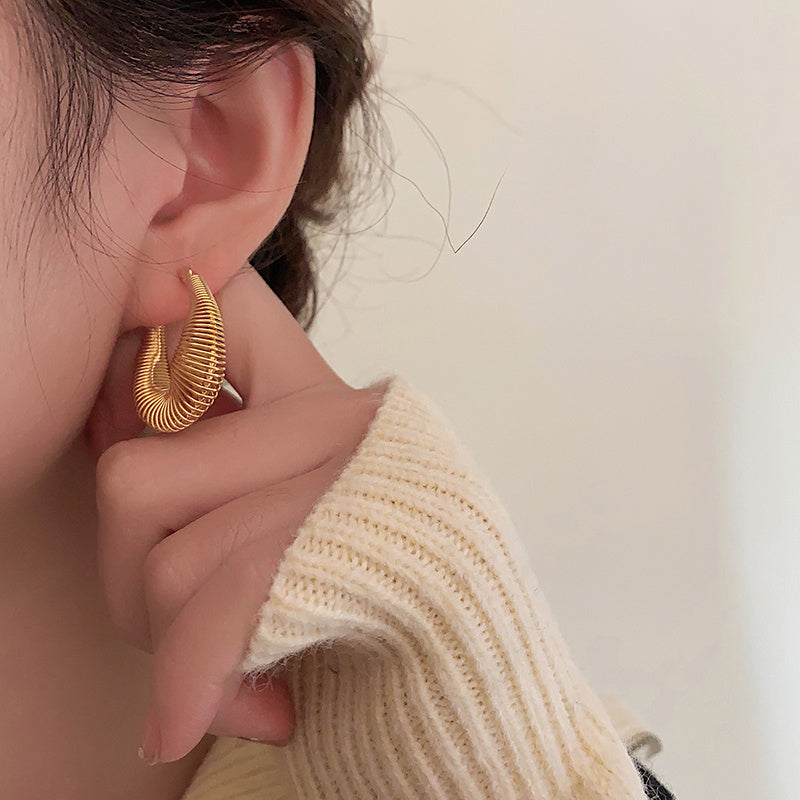 Trendy gold dainty hoop earrings USA worn by a model showcasing a stylish outfit