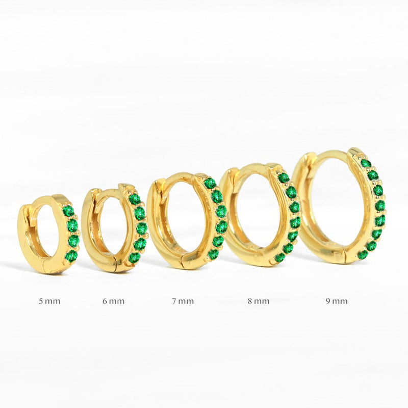Assorted sizes of gold huggie earrings with green stones, perfect for everyday wear and styling